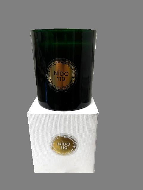 Black glass bottle with 'Nido 110' label on a white box against a gray background. soy wax cotton wicks