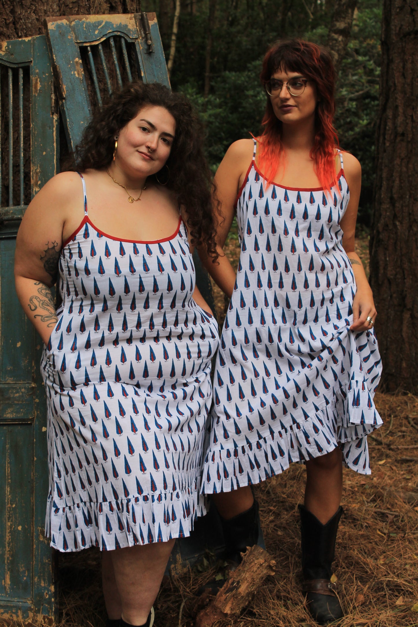 two models showcasing white navy and red nightdress with spaghetti straps, frill hem with pockets in forest scene